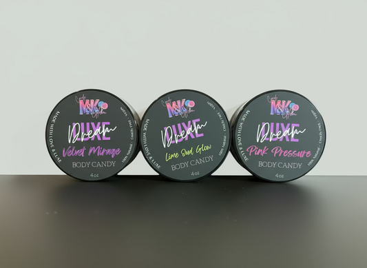 Three containers of body candy with colorful labels on a gray surface.