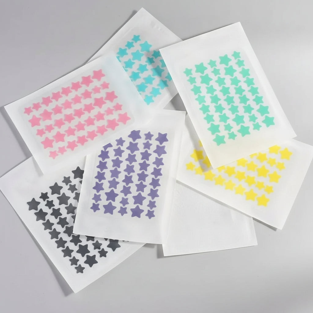 Set of star-shaped stickers in various colors on a textured white surface